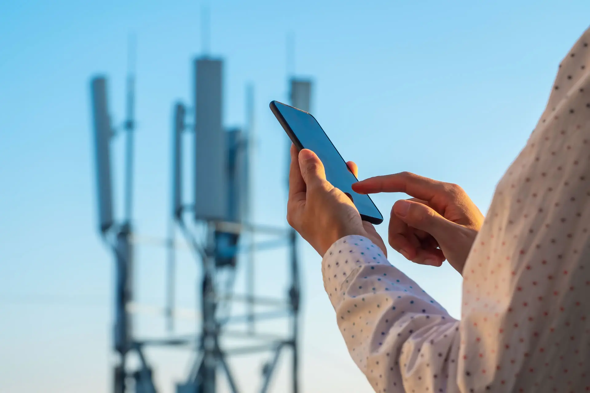 Phone towers and hand with phone