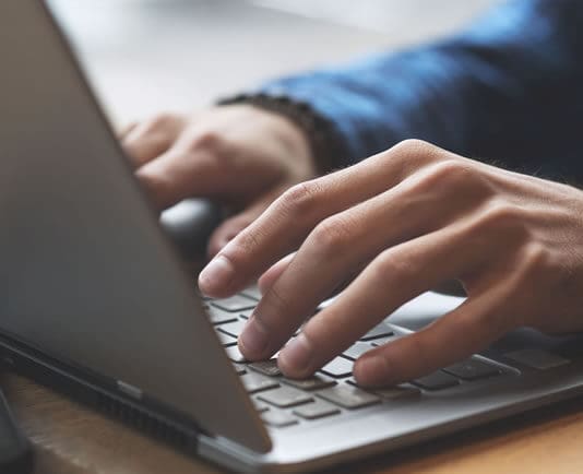 person's hands on laptop