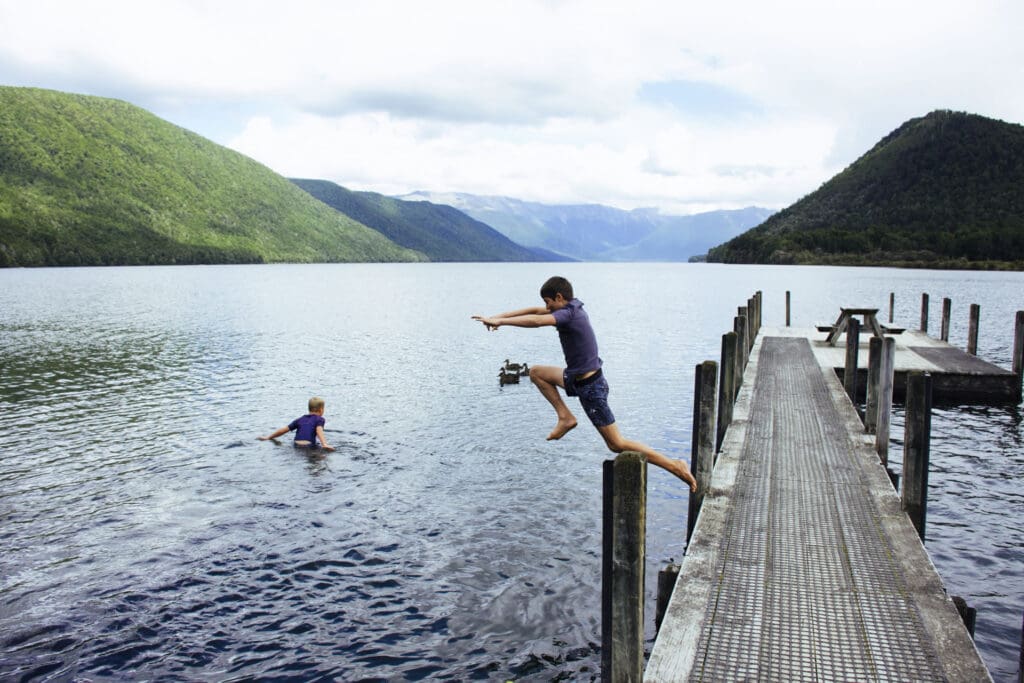 Children Jumping off Pier, Nelson Lakes, New Zealand stock photo