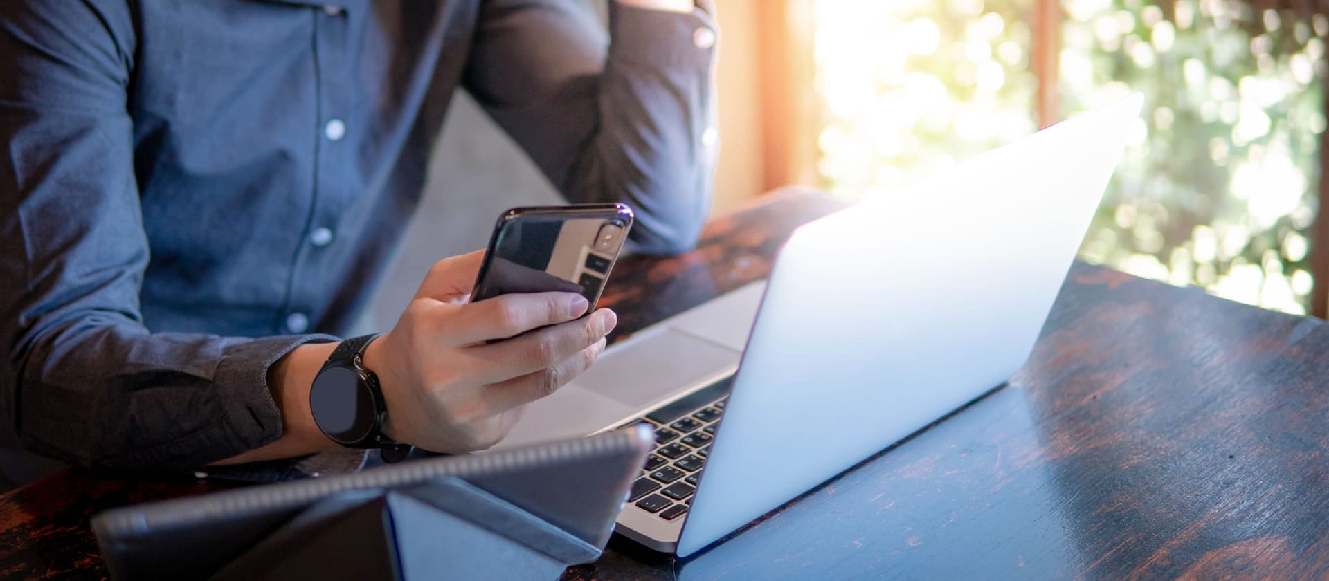Person with phone and laptop