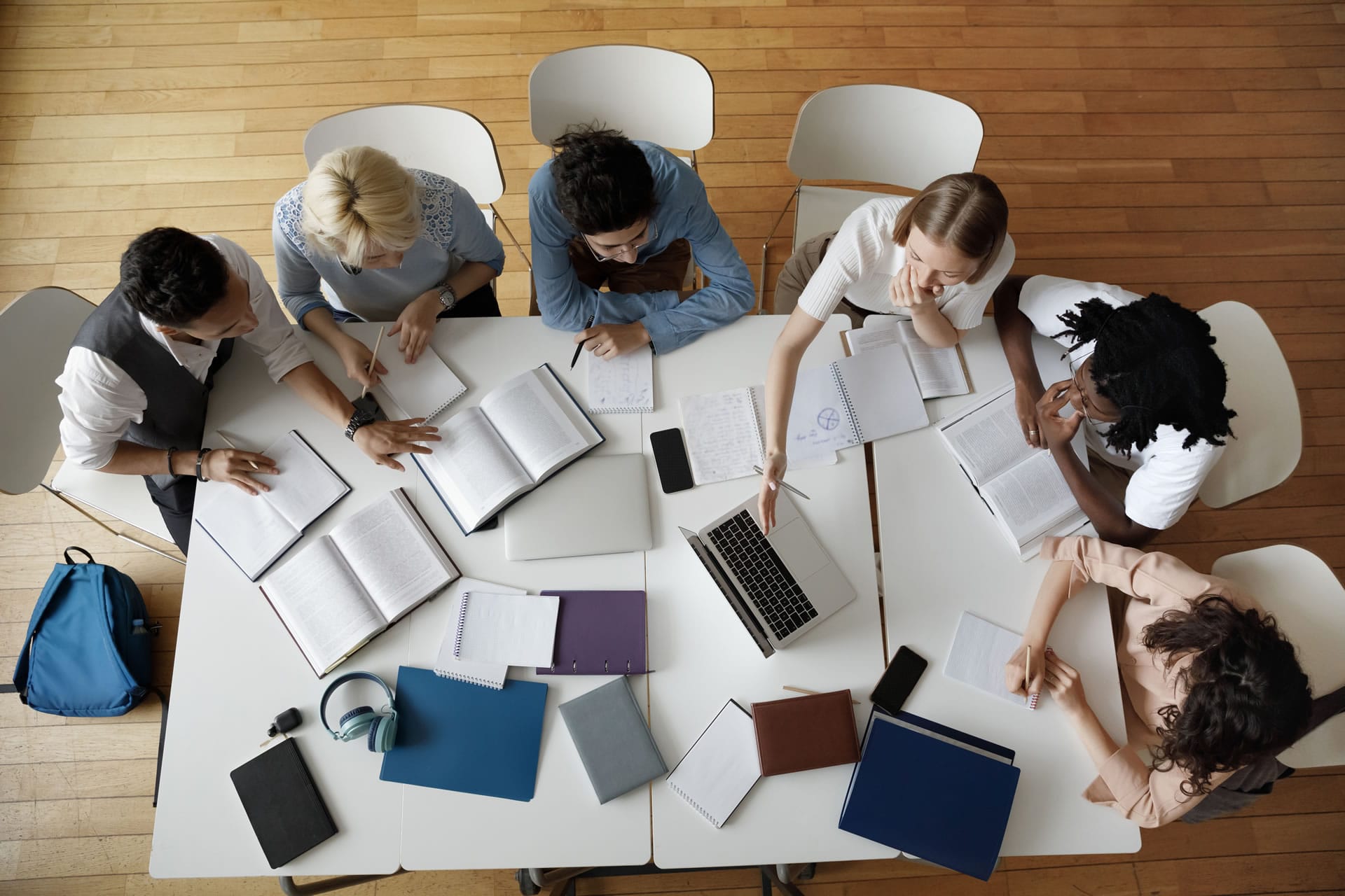 Team around table with laptops from above