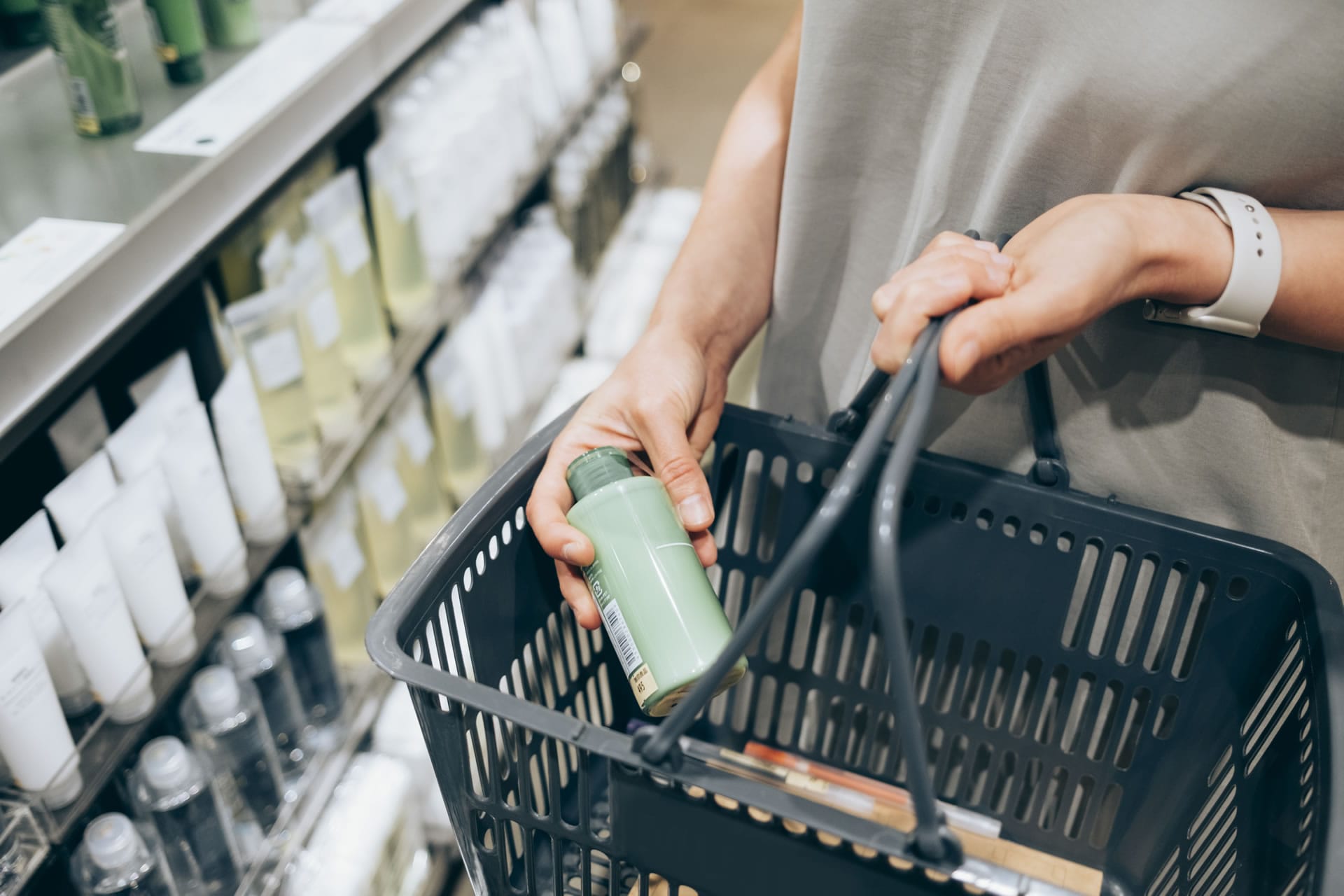 Shopper with basket in pharmacy aisle