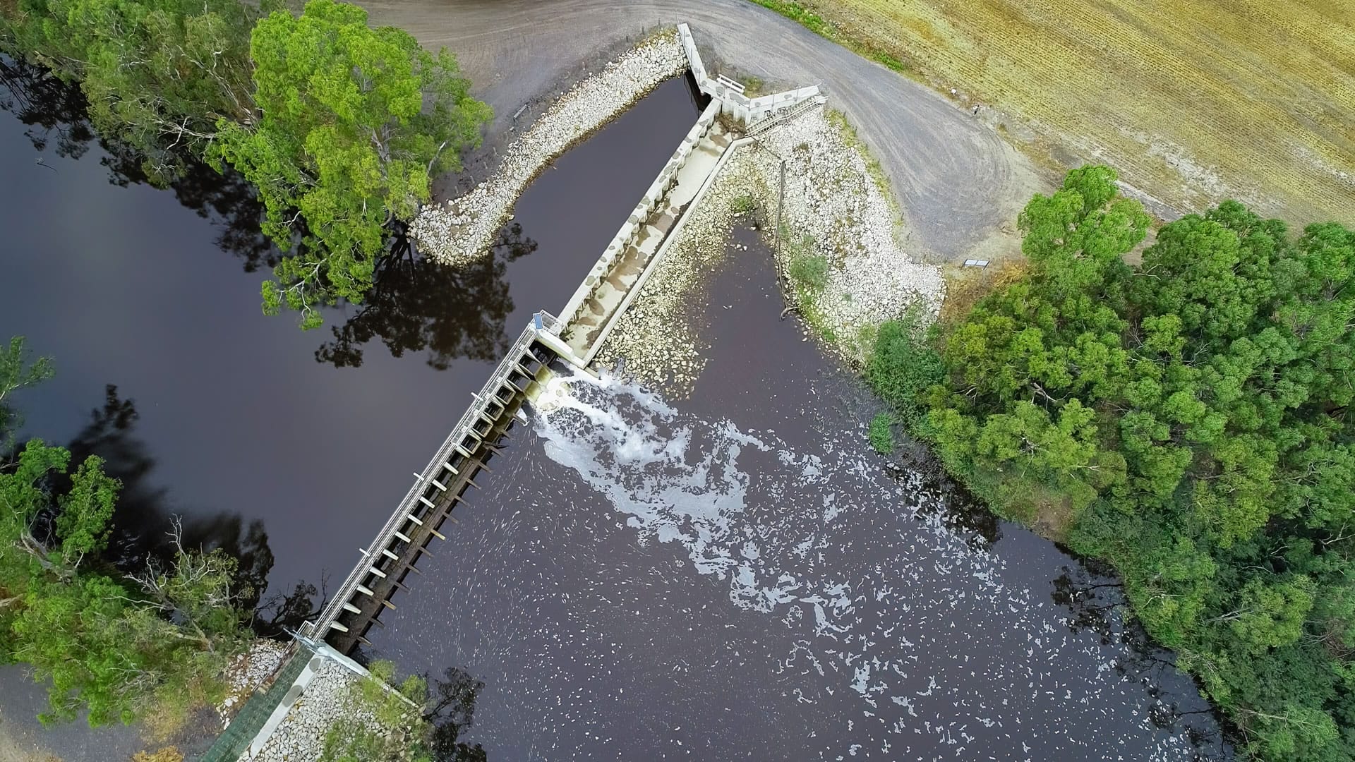 Weir with water flowing, aerial